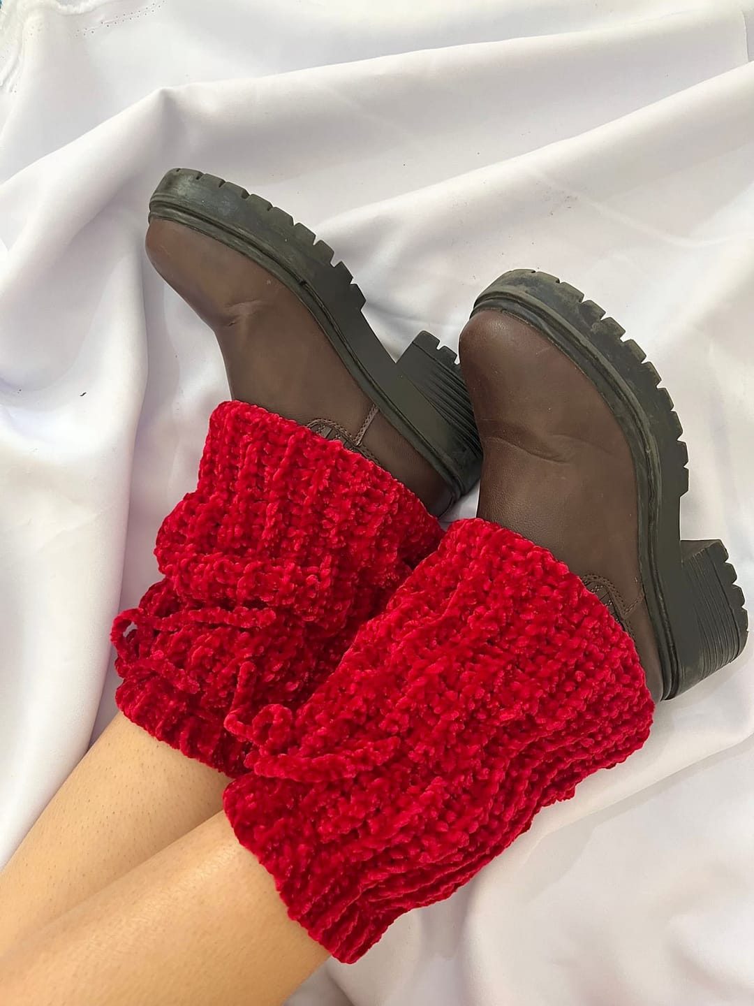 Calentadores tejidos a crochet en chenille rojo, puestos con botas