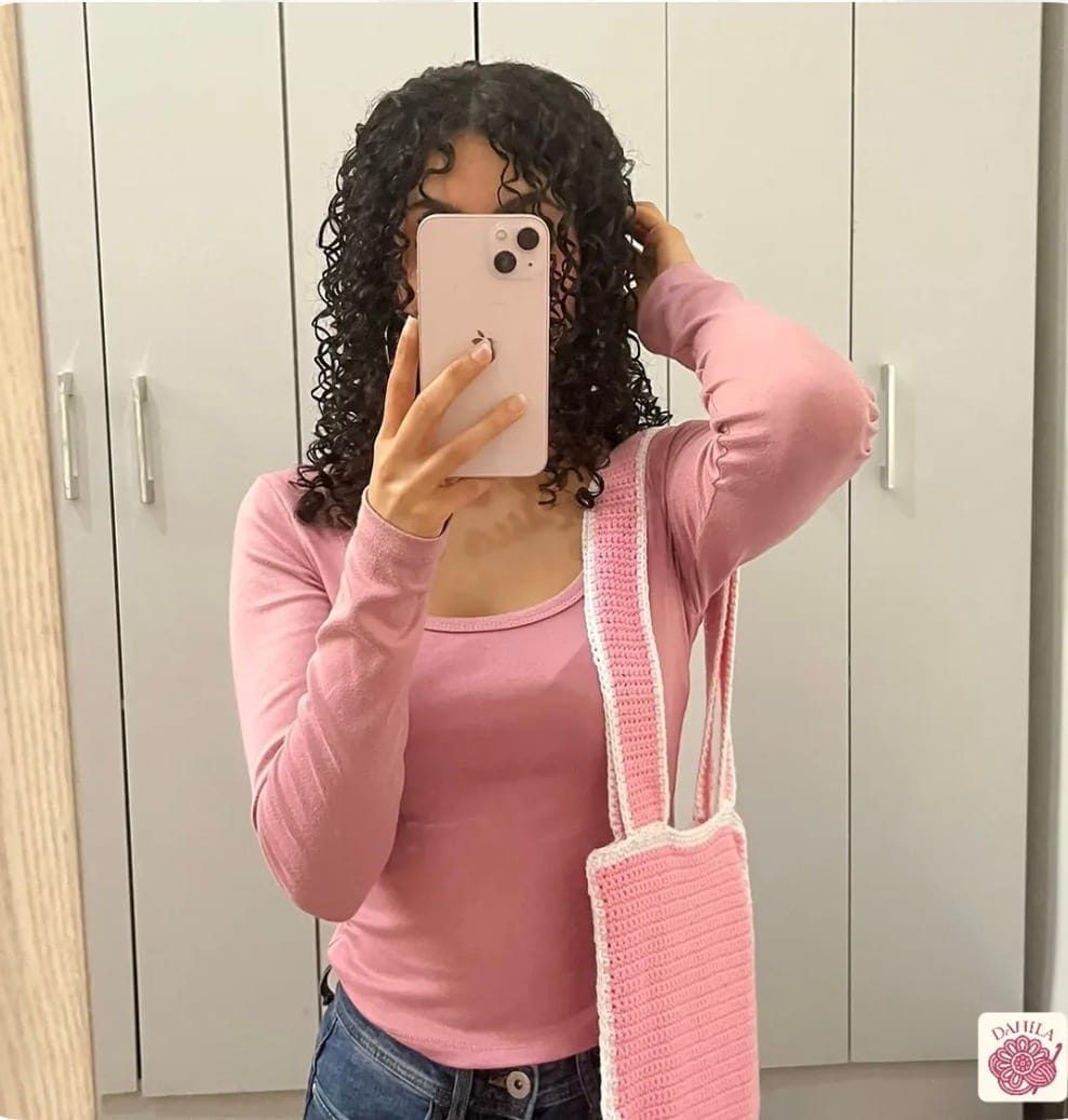 Mini tote tejida a crochet en rosa, colgada del hombro