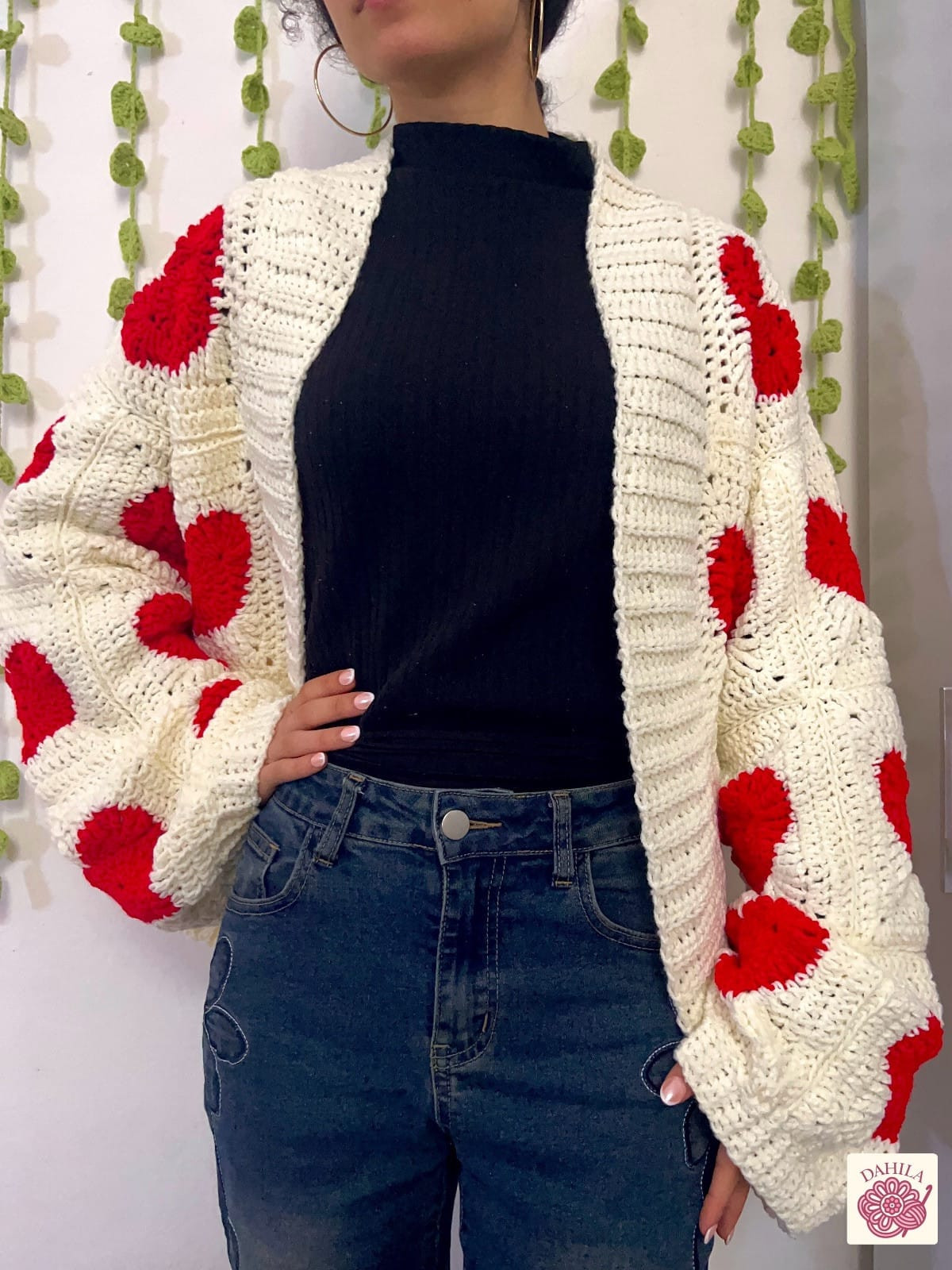 Cardigan amour tejido a crochet en crudo con corazones rojos, puesto con jean